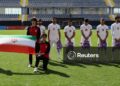 Jogadores iranianos de futebol seguram mochilas escolares em protesto por meninas mortas